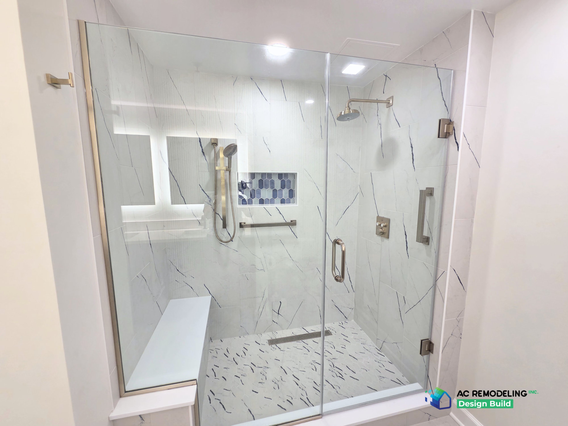 Walk-in shower with bench seat, rainhead and marble-look tile walls