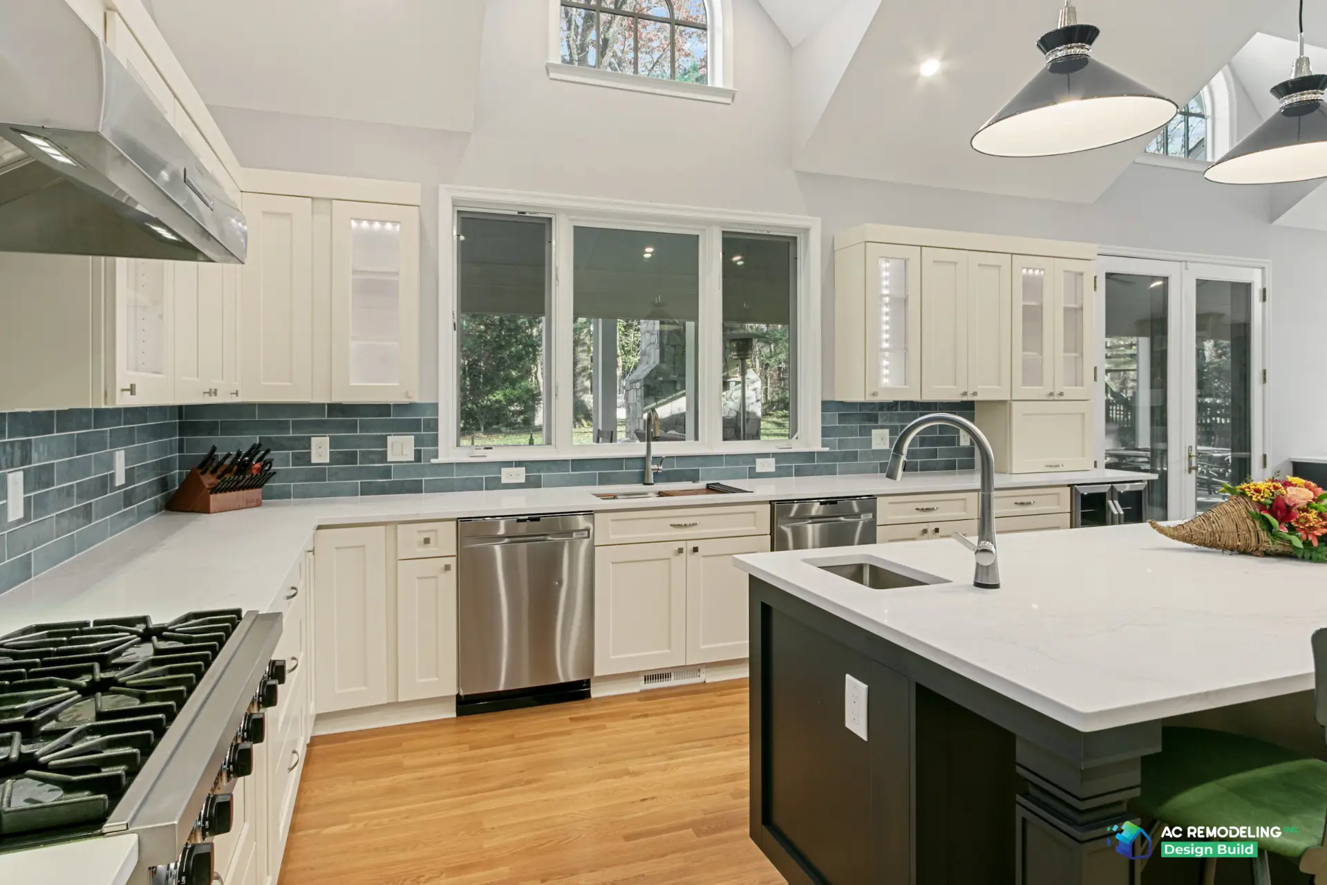 Finished kitchen with vaulted ceiling, blue tile backsplash, and quartz island with prep sink