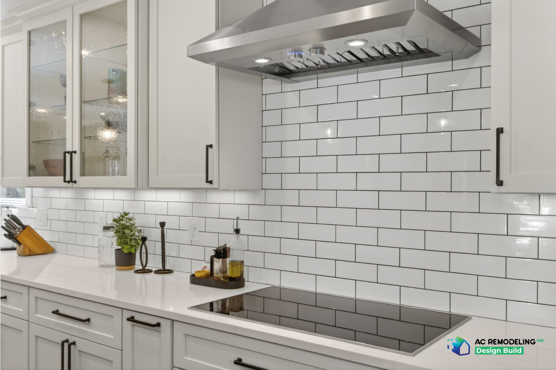 Kitchen backsplash in white subway tile with stainless range hood and induction cooktop