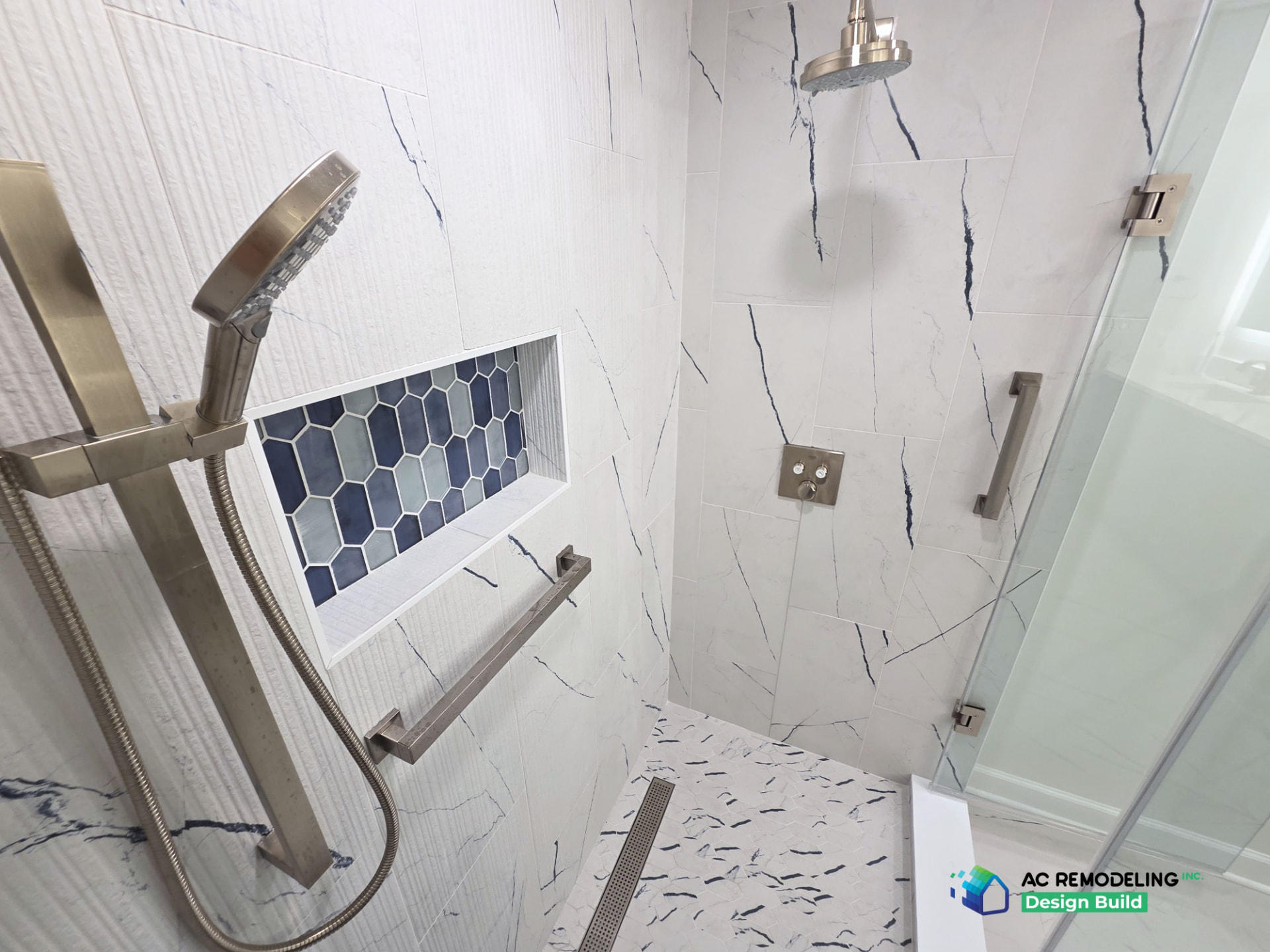 Marble-look shower with linear drain, blue hex niche and brushed nickel fixtures