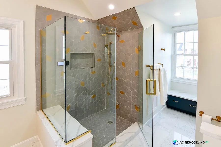 The master bathroom boasts a spacious shower with a comfortable bench, a soothing rain shower head, and an eye-catching 3D cube wall design. The shower area is elegantly enclosed by a glass door, combining style and practicality.